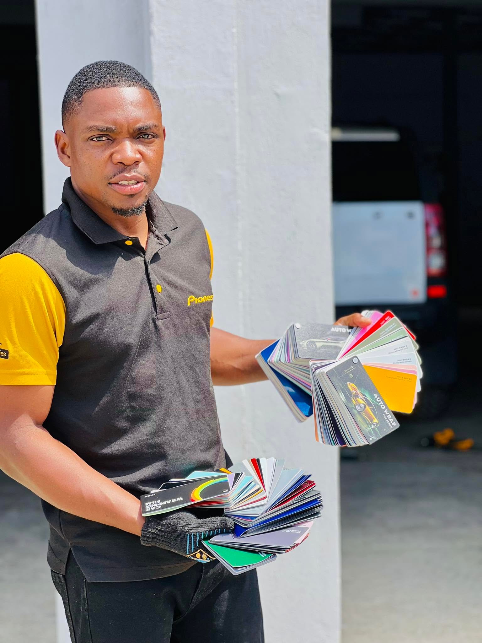 ZED technician holding vehicle wrap film colour swatches